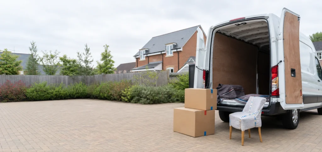 White removal van with a few boxed items on a residential driveway